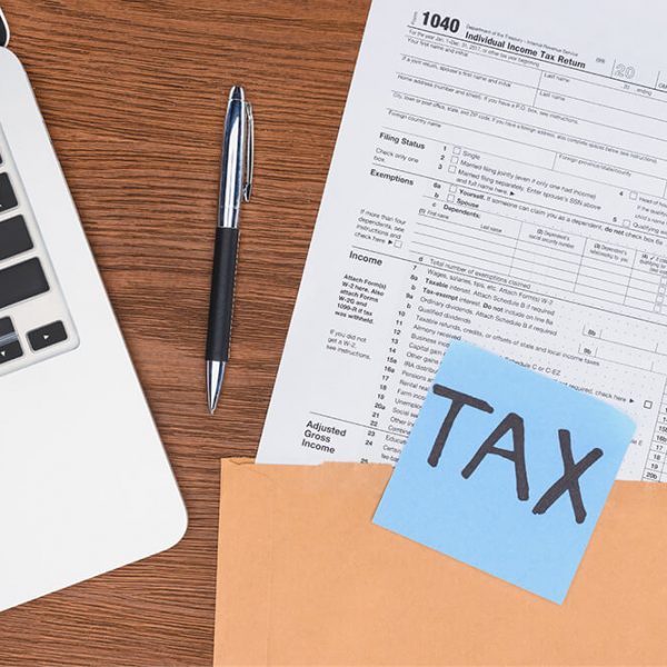 top-view-of-tax-form-laptop-and-blue-card-with-tax-AZC32TD